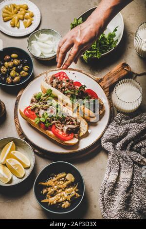 Mans Hand über Türkische traditionelle Fleisch sandwich tantuni Stockfoto