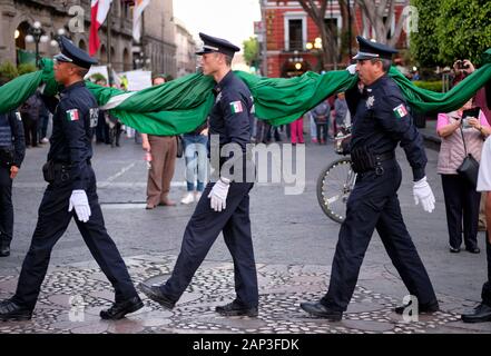 Puebla, Mexiko. Zeremonielle Absenken der Mexikanischen Flagge von der städtischen Polizei in zentralen Platz Stockfoto