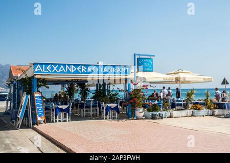 Kardamena an, Kos, Griechenland - 20. September 2019: Menschen zu Fuß entlang der Promenade vorbei an der Restaurant Alexander. Die Stadt ist ein beliebtes Ferien destina Stockfoto