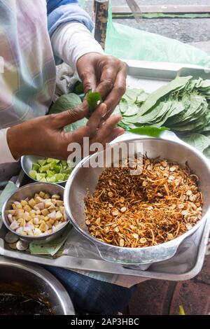 Eine Straße Nahrung Verkäufer Vorbereitung Betelnuss umschließt (Miang Kham). Dies ist ein beliebter Snack unter den Thais. Stockfoto