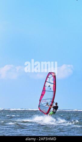 Windsurfen ist ein beliebter Surfsport, der sowohl Segeln als auch Surfen ist.Pagudpud, Ilocos Norte, ist ein Windsurfziel für seine Windkraft. Stockfoto