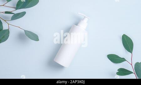 Pumpe Plastikflasche für intime gel Dispenser oder flüssige Seife auf blauem Hintergrund mit grünen Eukalyptus Blätter. Intime Hygiene, Kosmetik SPA Brandin Stockfoto