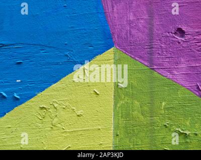 Bunt bemalte Puzzleformen auf strukturiertem Sperrholz Stockfoto