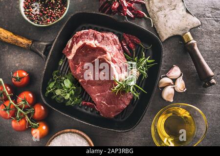 Rindfleisch ribe Eye Steak in der Grillpfanne mit Rosmarin oregano Salz Pfeffer Gewürze Knoblauch und Tomaten Stockfoto