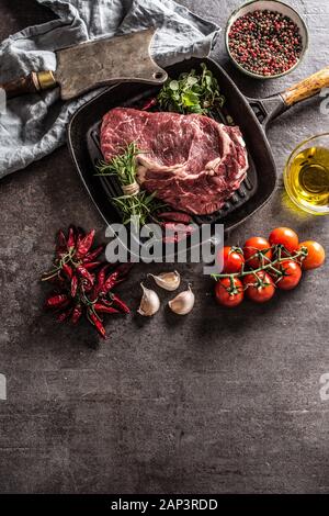 Rindfleisch ribe Eye Steak in der Grillpfanne mit Rosmarin oregano Salz Pfeffer Gewürze Knoblauch und Tomaten Stockfoto