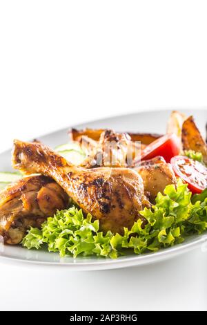 Gebratene Hähnchenschenkel mit Salat Salat Kartoffeln und Tomaten isoliert auf weißem Stockfoto