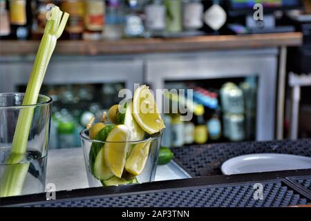 Barkeeper schneidet die Artikel an der Bar draußen, um sie zu den harten Likörgetränken hinzuzufügen Stockfoto