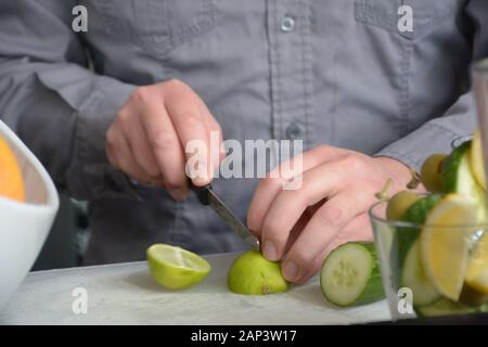 Barkeeper schneidet die Artikel an der Bar draußen, um sie zu den harten Likörgetränken hinzuzufügen Stockfoto