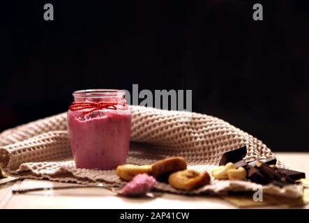 Rosa cremige Smoothie in der Flasche. Farbenfrohen drink, Milch Shake in Flasche mit frischem Gemüse und Superfoods auf einer hölzernen Hintergrund. Gesund, sauber Stockfoto