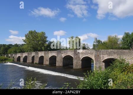 Die Brücke der Klasse 1 Aus dem 18. Jahrhundert, die über einem Wehr über den Fluss Usk in Crickhowell, Powys, Wales, Großbritannien Steht Stockfoto