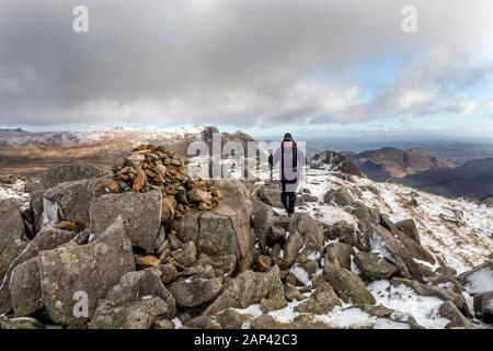 Walker nähert sich dem Gipfel Cairn auf Rossett Pike, Lake District, Cumbria, Großbritannien Stockfoto