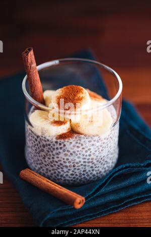 Chia Pudding mit Kokosmilch und Banane in Gläser auf einen Tisch. Vegetarische gesunde Dessert. Stockfoto