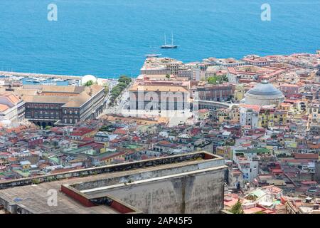 Luftaufnahme des historischen Stadtzentrums von Neapel mit der Kirche San Francesco di Paola, der Piazza del Plebiscito und dem Königspalast von Neapel mit Meer. Stockfoto