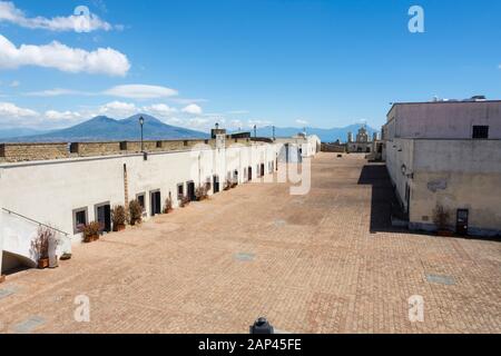 Castel sant'Elmo ist eine mittelalterliche Burg, die als Museum genutzt wird und sich auf dem Hügel Vomero bei San Martino in Neapel befindet. Vulkan Vesuv im Hintergrund. Stockfoto