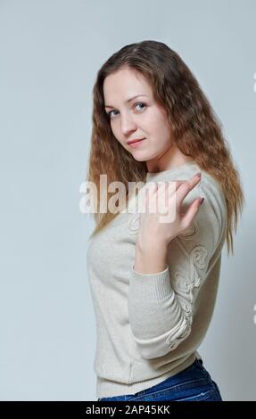 Junge Frau vor der Kamera mit dem lockigen Haar posing Stockfoto