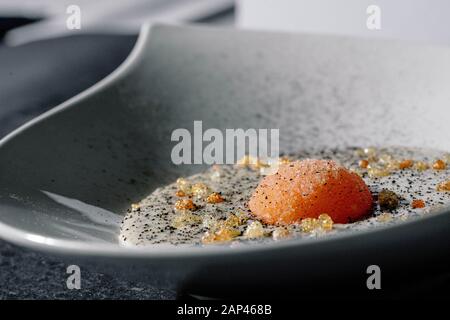 Cremefarbene Suppe mit halbgekochtem Eigelb und mit schwarzem Pfeffer und Trüffel Stockfoto