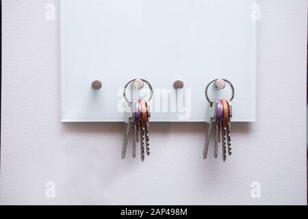 Schlüssel hängen an moderner offener Schlüsselbox für Aufbewahrungsschlüssel an weißer Wand Stockfoto