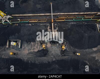 Laden Kohle Anthracite Mining im Hafen auf Cargo tanker Schiff mit Kran Eimer von Zug. Antenne Top View Stockfoto