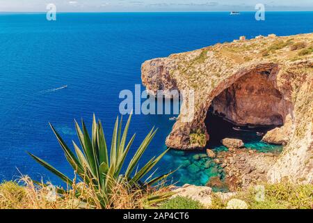 Blaue Grotte auf Malta. Vergnügungsboot mit Touristen fährt. Naturbogenfenster in Felsen Stockfoto