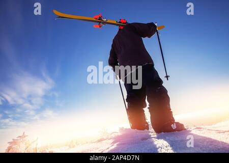 Skifahrer fahren im sonnigen Tag in den Bergen und im Wald bergab. Extrem-Wintersport Stockfoto