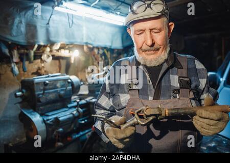 Älterer, älterer Mechaniker für Wender, der an Werkzeugmaschinen für Metall arbeitet Stockfoto