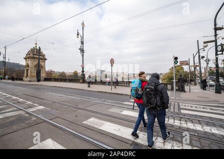 Prag, TSCHECHIEN - 1. NOVEMBER 2019: Gruppe von zwei jungen Reisenden, ein Rucksacktouristenpaar, die mit ihren Rucksäcken in der Altstadt spazieren gehen, mit einem Stockfoto