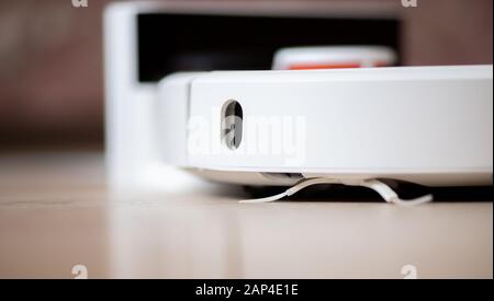 Intelligenter Roboter-Staubsauger mit intelligentem Staubsauger, der auf Laminatboden arbeitet Stockfoto