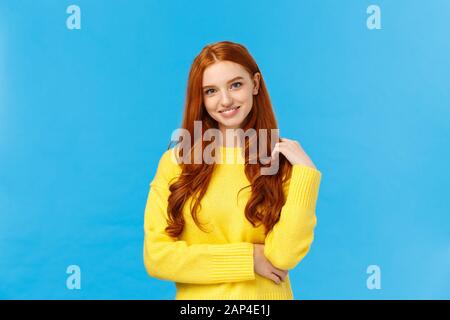 Taille-up-Shot attraktiv flirrrriger Rotkopf modernes Mädchen tausendjährige in gelbem Pullover, mit Haaren und lächelnd schön mit Unterhaltung, neugierig Stockfoto