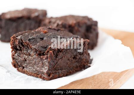 Auf der Basis von veganen Schokoladenbrownies aus Süßkartoffeln auf weißem Hintergrund selektiver Fokus für den Kopierbereich Stockfoto