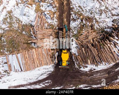 Holzfällerholz mit modernen Feldhäckslern, die im Wald arbeiten. Luftbild Draufsicht Stockfoto