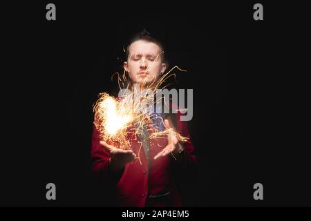 Magier zeigt Trick mit Brandbrand aus Handflächen Stockfoto