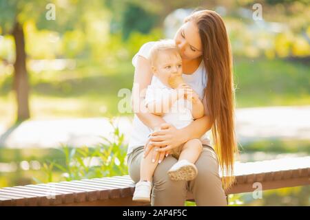 Mutter küsst Kindersohn, Junge isst Eis im Park Stockfoto