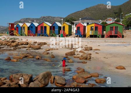 Bunte Strandhütten in der Nähe von Simons Stadt in der Kapregion von Südafrika machen schöne Kulisse für Strandkämmen und Angeln in den Wasserpools Stockfoto