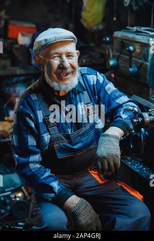 Ältere ältere männliche Dreher bearbeiten Metall an der Maschine. Konzept Rentenarbeiter Industrie, Arbeitsplatz Stockfoto