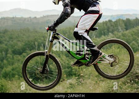 Fahrer Athlet Abfahrt Sprung auf Wald und Berge Hintergrund Wettkampf Rennen Stockfoto