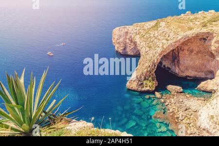 Blaue Grotte auf Malta. Vergnügungsboot mit Touristen fährt. Naturbogenfenster in Felsen Stockfoto