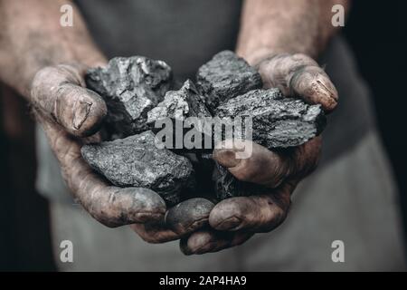 Bergmann schmutzige Hände halten Kohle. Konzeptindustrie Bergbau Stockfoto