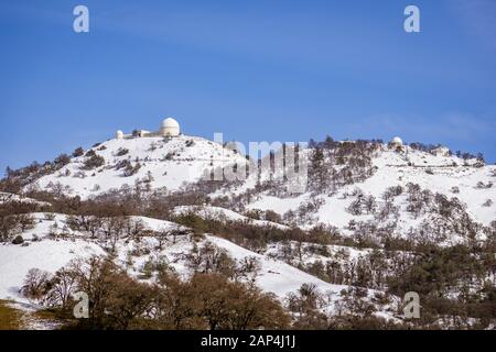 Blick auf die Spitze des Mt Hamilton an einem klaren Wintertag, Schnee, der den Gipfel und die umliegenden Hügel, San Jose, San Francisco Bay Area, Calif Stockfoto