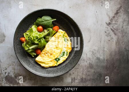 Spinatomelett mit gemischtem Grünsalat Stockfoto