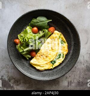 Spinatomelett mit gemischtem Grünsalat Stockfoto