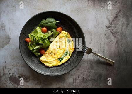 Spinatomelett mit gemischtem Grünsalat Stockfoto