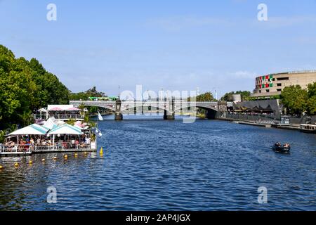 Fauler sonniger Nachmittag auf dem Yarra River, Melbourne, Australien mit schwimmendem Restaurant, Booten, Brücke, Straßenbahn und MGG im Hintergrund Stockfoto
