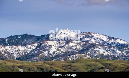 Blick auf die Spitze des Mt Hamilton an einem klaren Wintertag, Schnee, der den Gipfel und die umliegenden Hügel, San Jose, San Francisco Bay Area, Calif Stockfoto