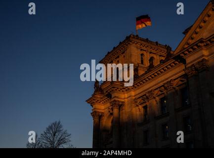 Berlin, Deutschland. 21 Jan, 2020. Die aufgehende Sonne badet der Reichstag in ein besonderes Licht. Credit: Paul Zinken/dpa/Alamy leben Nachrichten Stockfoto