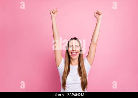 Foto der faszinierenden attraktiven Dame, die aufgeregt die Stimmung feiert, die Hände aufhebt, unterstützt die Cheerleaderin des Teams tragen Casual weißes T-Shirt isoliert rosa Farbe Stockfoto