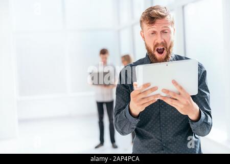 Überrascht Geschäftsmann SMS lesen auf seinem Tablet Stockfoto