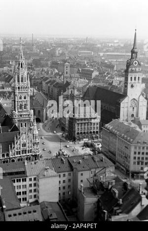 Blick auf den Marienplatz in München, links das Neue Rathaus, dahinter das Alte Rathaus, rechts Heilig-Geist-Kirche und St. Peter, 1957 sterben. Blick auf Maria's Square, München, auf der linken das Neue Rathaus mit dem Alten Rathaus hinaus, die Kirche des Heiligen Geistes und St. Peter auf der Rechten, 1957. Stockfoto