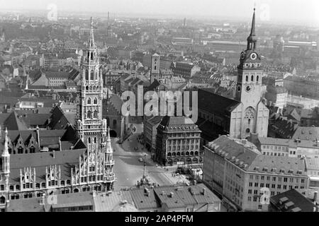 Blick auf den Marienplatz in München, links das Neue Rathaus, dahinter das Alte Rathaus, rechts Heilig-Geist-Kirche und St. Peter, 1957 sterben. Blick auf Maria's Square, München, auf der linken das Neue Rathaus mit dem Alten Rathaus hinaus, die Kirche des Heiligen Geistes und St. Peter auf der Rechten, 1957. Stockfoto