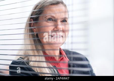 Nachdenklich Geschäftsfrau, stehen in der Nähe der Fenster office Stockfoto
