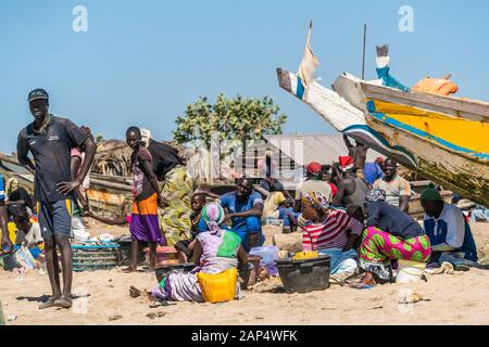 Die Frauen der Fischer mit den Fischerboote am Strand von Sanyang, Gambia, Westafrika | Fisherman's Frau mit ihren bunten Fischerboote bei t Stockfoto